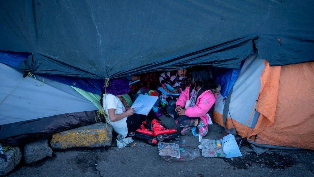 TOPSHOT - Children play at an encampment of Mexican asylum seekers by the Paso del Norte International Bridge in Ciudad Juarez, Mexico, on December 13, 2019. - In the mud and biting cold of a makeshift camp in the border city of Ciudad Juarez, more than 1,000 Mexican migrants had been waiting for weeks, some for months, for a chance to file for asylum in the United States. This week their numbers fell this week by half -- to around 700 -- as hundreds gave up hope of ever crossing the border. (Photo by Paul Ratje / AFP) (Photo by PAUL RATJE/AFP via Getty Images)
