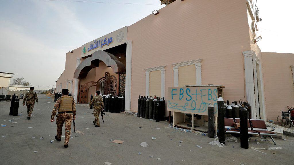 Members of Iraqi security forces stand at the gate of Ibn Al-Khatib Hospital in Baghdad, on April 25, 2021, after a fire erupted in the medical facility reserved for the most severe COVID-19 cases. - At least 23 people died when a fire broke out in a coronavirus intensive care unit in the capital of Iraq, a country with long-dilapidated health infrastructure facing mounting COVID-19 cases. (Photo by AHMAD AL-RUBAYE / AFP) (Photo by AHMAD AL-RUBAYE/AFP via Getty Images)