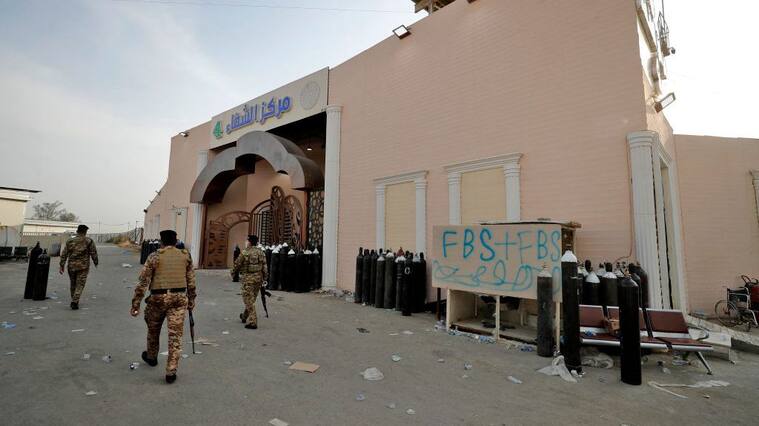 Members of Iraqi security forces stand at the gate of Ibn Al-Khatib Hospital in Baghdad, on April 25, 2021, after a fire erupted in the medical facility reserved for the most severe COVID-19 cases. - At least 23 people died when a fire broke out in a coronavirus intensive care unit in the capital of Iraq, a country with long-dilapidated health infrastructure facing mounting COVID-19 cases. (Photo by AHMAD AL-RUBAYE / AFP) (Photo by AHMAD AL-RUBAYE/AFP via Getty Images)