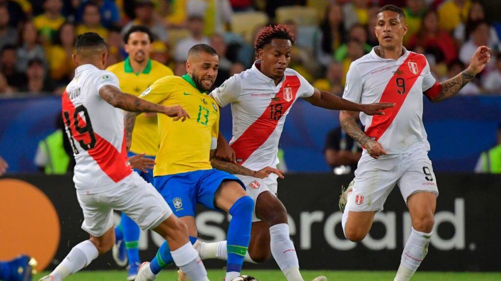 Brazil's Dani Alves, Peru's Andre Carrillo (2nd R) and Peru's Yoshimar Yotun (L) vie for the ball during their Copa America football tournament final match at Maracana Stadium in Rio de Janeiro, Brazil, on July 7, 2019. (Photo by Luis Acosta / AFP) (Photo credit should read LUIS ACOSTA/AFP via Getty Images)