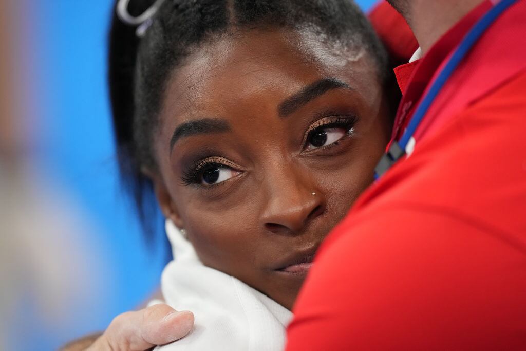 La gimnasta Simone Biles recibe un abrazo durante la competencia de Tokio