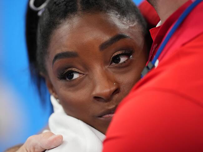 La gimnasta Simone Biles recibe un abrazo durante la competencia de Tokio
