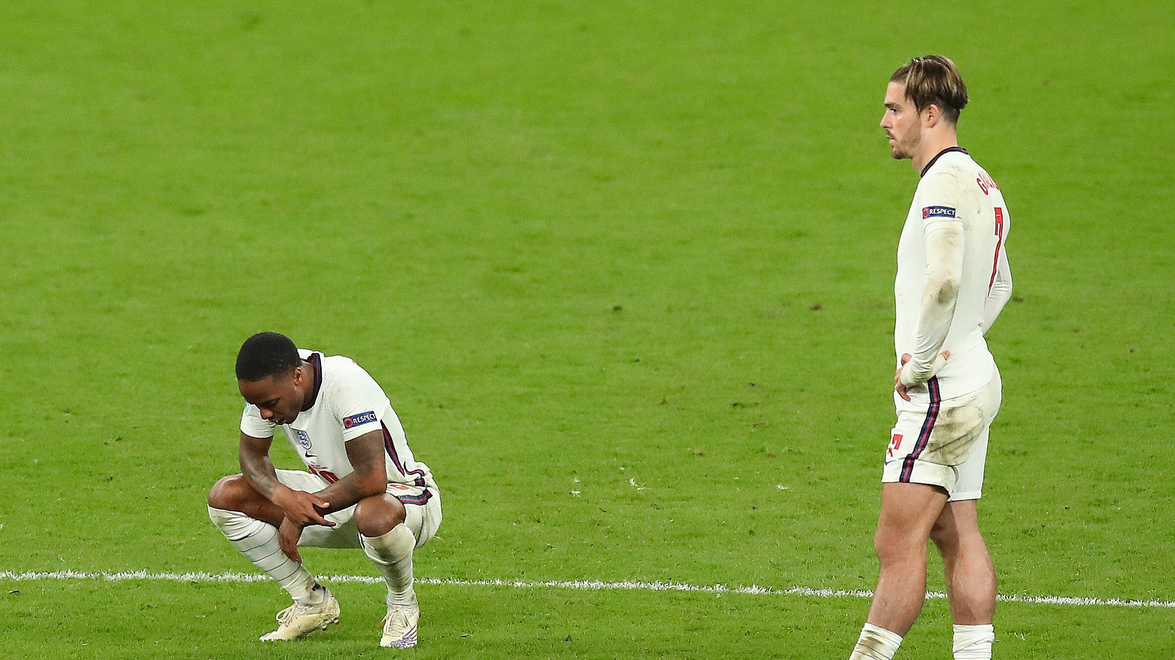 LONDON, ENGLAND - JULY 11: A dejected Raheem Sterling and Jack Grealish of England after losing the penalty shoot out during the UEFA Euro 2020 Championship Final between Italy and England at Wembley Stadium on July 11, 2021 in London, United Kingdom. (Photo by Robbie Jay Barratt - AMA/Getty Images)