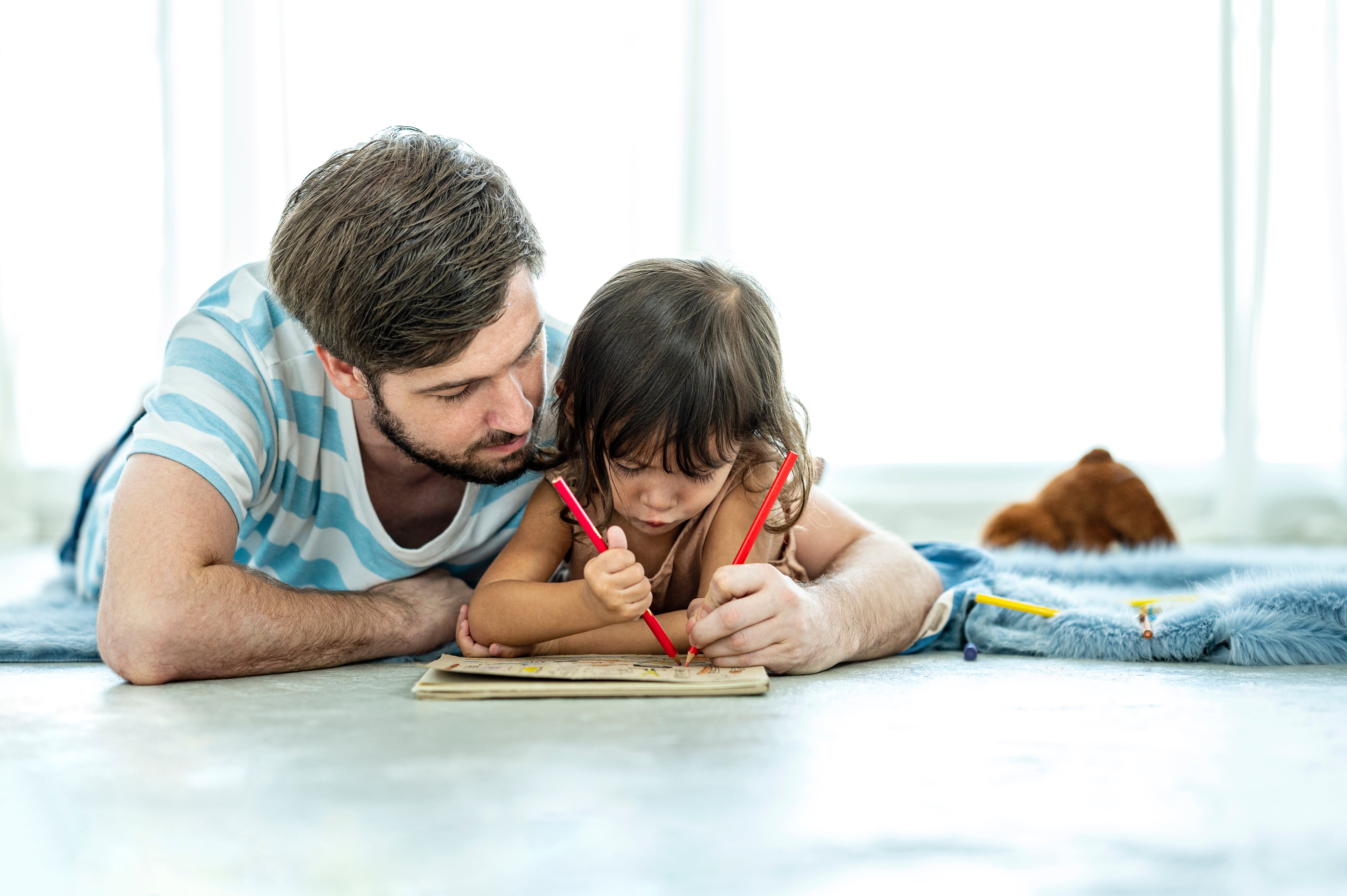 Unemployed stress father while teaching his daughter to drawing at home to relax of impact from corona-virus, lock-down from government.