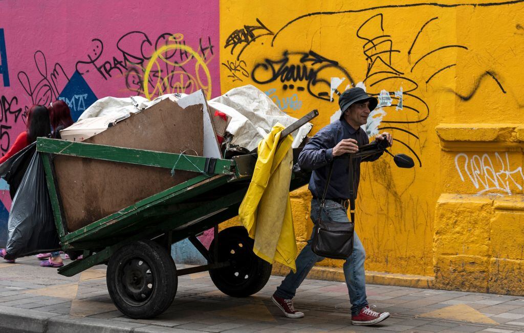 Un hombre camina por Bogota recolectando materiales para sobrevivir