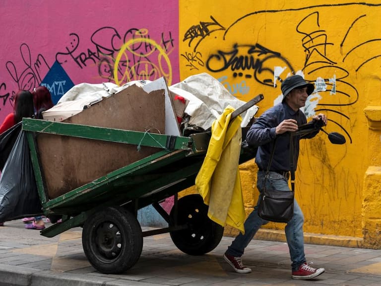 Un hombre camina por Bogota recolectando  materiales para sobrevivir
