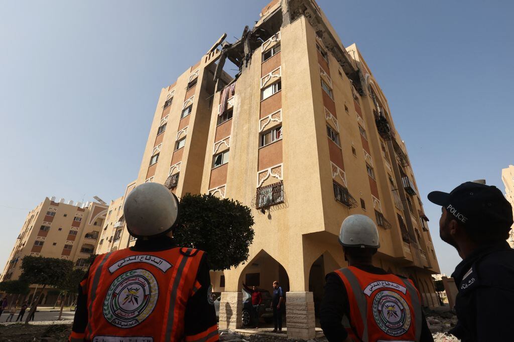 Funcionarios de la defensa civil de Palestina observan los daños tras los bombardeos