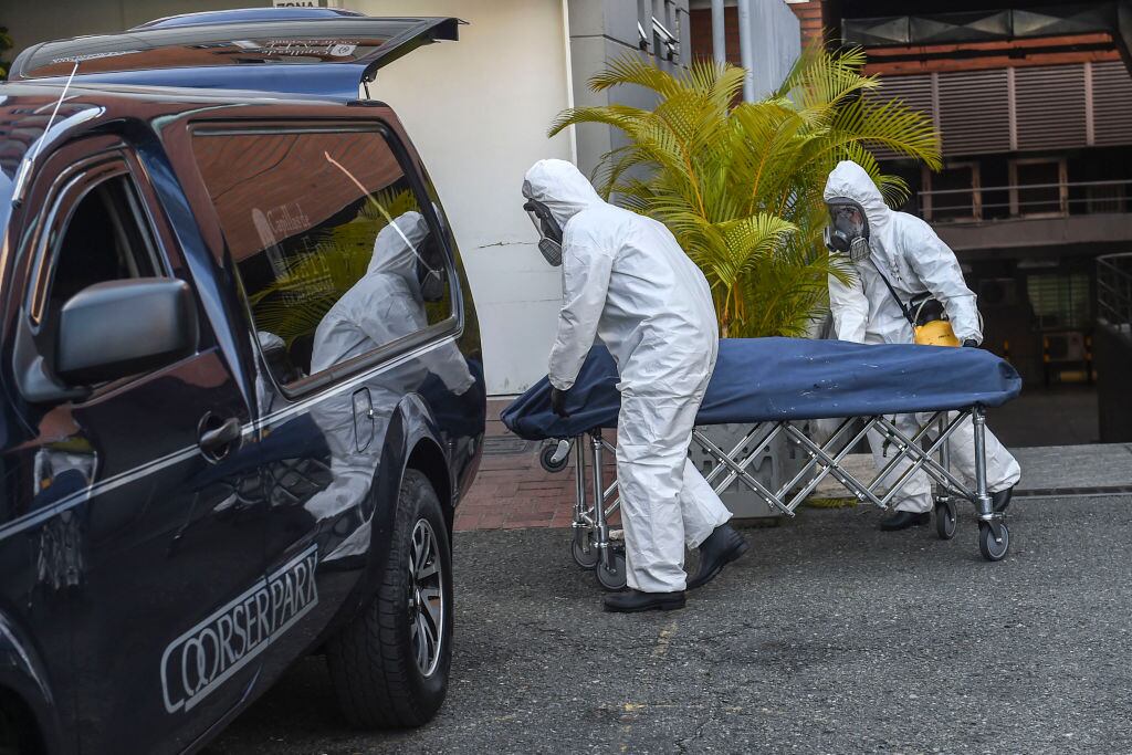 Trabajadores de funeraria retiran a una víctima del Covid-19 en Colombia