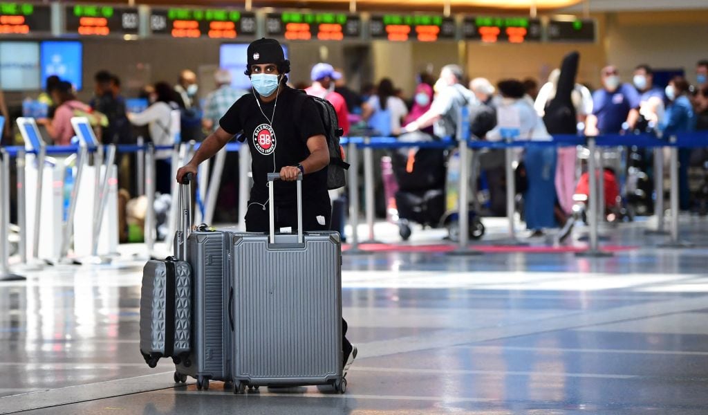 Hombre lleva maletas en el aeropuerto internacional de Los Angeles