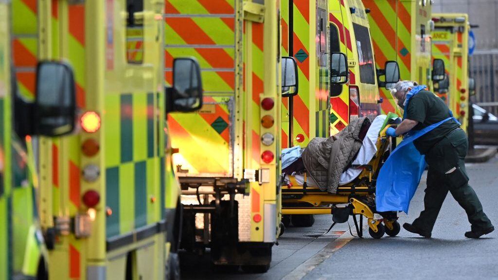 TOPSHOT - A paramedic is seen by a line of ambulances outside the Royal London Hospital in east London on January 5, 2021. - England's six-week lockdown, which began at midnight, emulates the first national coronavirus curbs in place from March to June -- but goes further than another instituted in November when schools remained open. Authorities in Wales, Scotland and Northern Ireland have all taken similar measures, putting the UK as a whole in lockdown. (Photo by JUSTIN TALLIS / AFP) (Photo by JUSTIN TALLIS/AFP via Getty Images)
