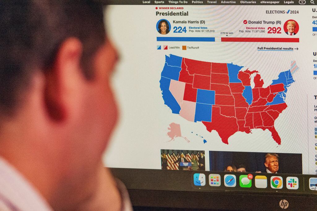 Un hombre mira en la pantalla del computador el detalle por estados de la definición en la elección presidencial en Estados Unidos
