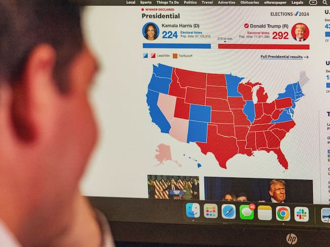 Un hombre mira en la pantalla del computador el detalle por estados de la definición en la elección presidencial en Estados Unidos