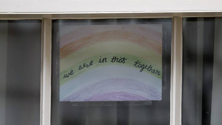 A poster of a rainbow, being used as a symbol of hope during the COVID-19 pandemic, with the words "we are in this together" is pictured in a window at 10 Downing Street, the official residence of Britain's Prime Minister, in central London on April 8, 2020, ahead of the Government's daily COVID-19 news briefing. - Britain's prime minister began a third day in intensive care battling the new coronavirus, which has struck at the heart of the British government, infected more than 55,000 people across the country and killed nearly 6,200. (Photo by Tolga AKMEN / AFP) (Photo by TOLGA AKMEN/AFP via Getty Images)