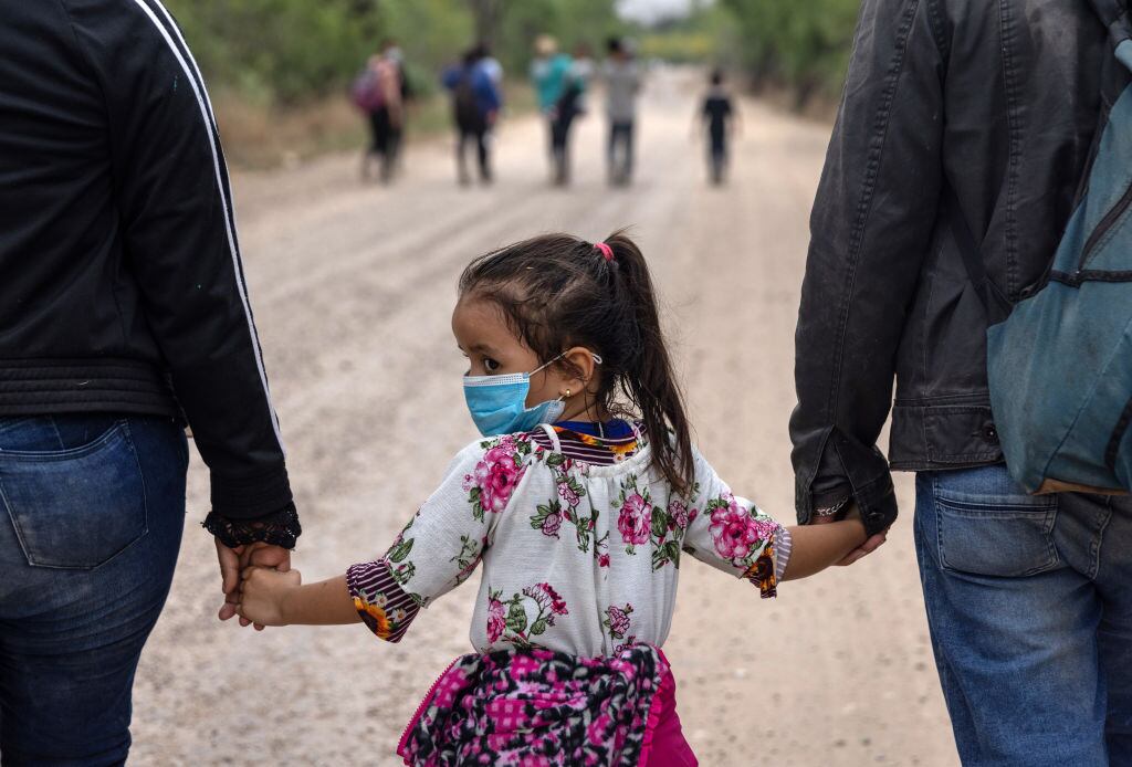 Una niña migrante camina por el estado de Texas con sus padres