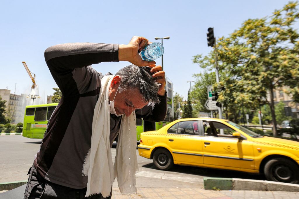 Hombre se lanza agua ante la fuerte ola de calor en la capital de Irán