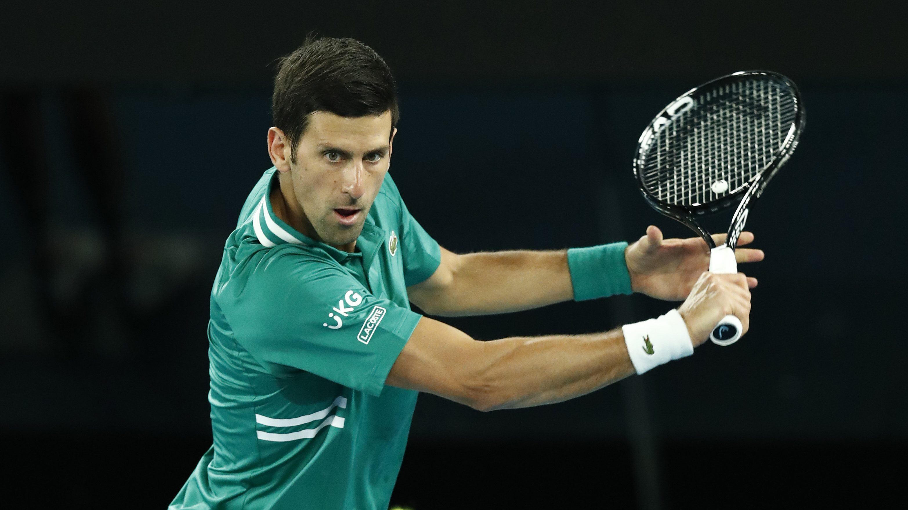 MELBOURNE, AUSTRALIA - FEBRUARY 08: Novak Djokovic of Serbia plays a backhand in his Men's Singles first round match against Jeremy Chardy of France during day one of the 2021 Australian Open at Melbourne Park on February 08, 2021 in Melbourne, Australia. (Photo by Darrian Traynor/Getty Images)