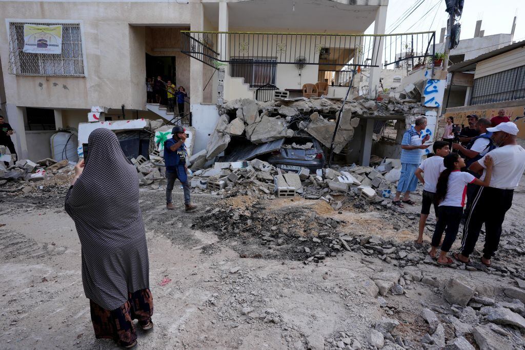 Personas observan el daño que dejan los militares de Israel que destruyen viviendas en el West Bank en Cisjordania de Palestina.
