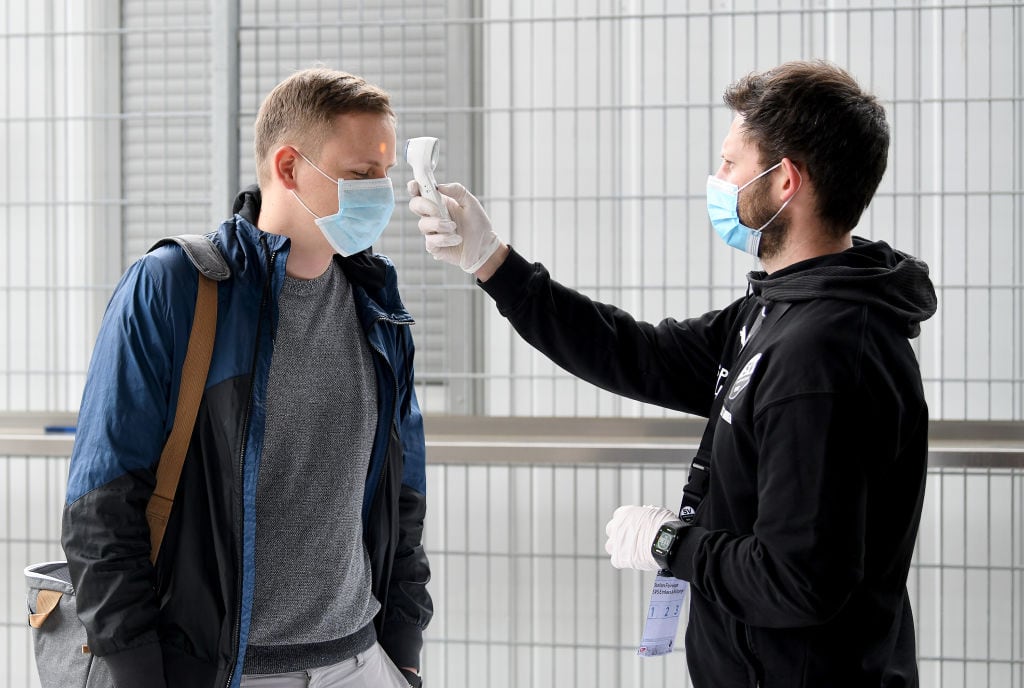 A un trabajador le miden la temperatura para ingresar a un estadio en Alemania