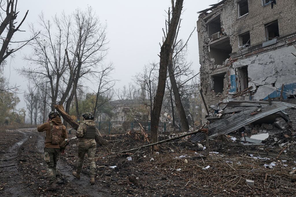 Unos soldados de Ucrania caminan entre los edificios atacados en Avdiivka