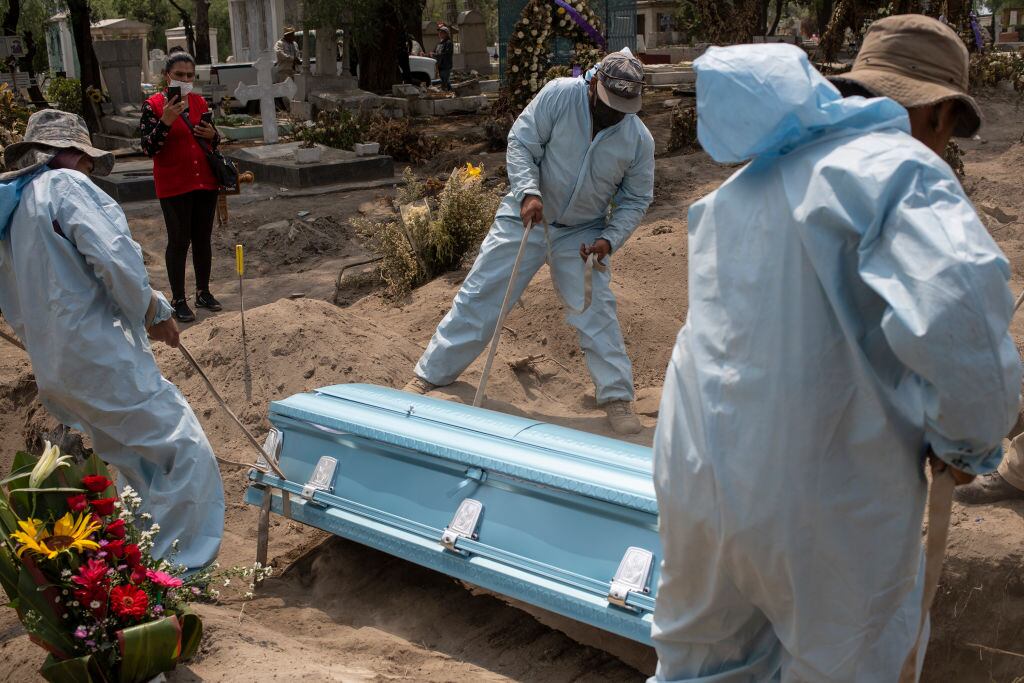 Trabajadores de un cementerio entierran a una víctima del Covid-19 en México