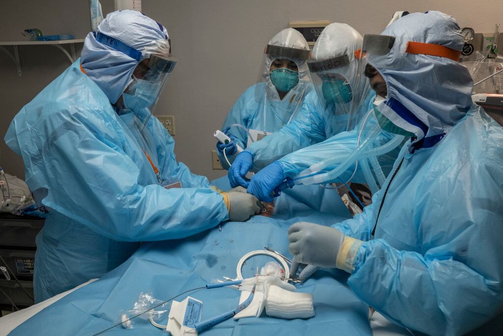 Médicos cirujanos operan a un paciente Covid-19 en un hospital de Houston