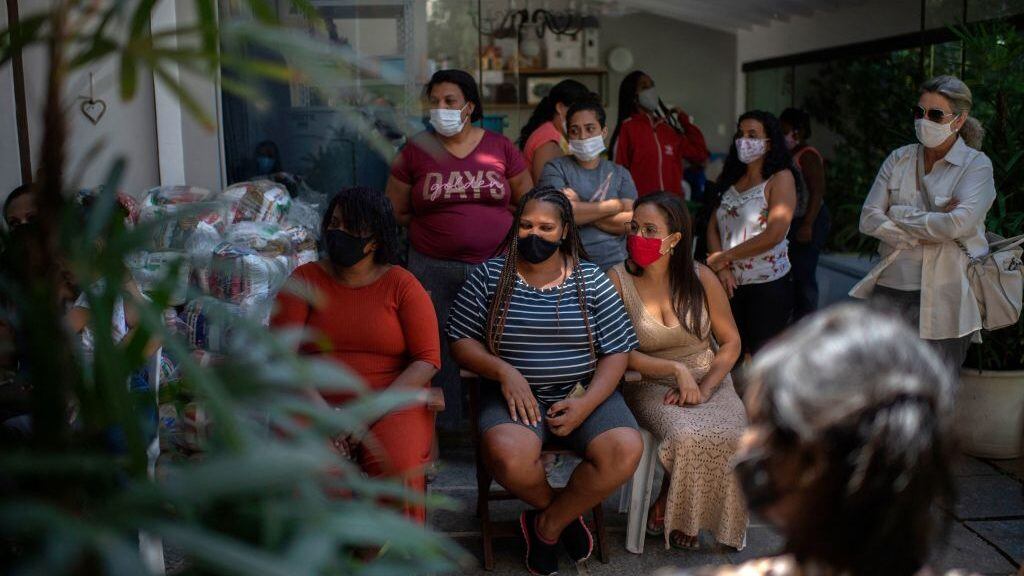 Mothers and other relatives of children with special needs attend a meeting at the NGO One By One, from which they receive sanitary pads, in Rio de Janeiro, Brazil, on October 22, 2021. - One By One is a non-profit organization for the social inclusion of low-income children with special needs, which provides them mobility through donated tailor-made wheelchairs and educational support. During the COVID-19 pandemic, the NGO started to assist more basic needs, including thedistribution of sanitary pads. (Photo by Mauro PIMENTEL / AFP) (Photo by MAURO PIMENTEL/AFP via Getty Images)