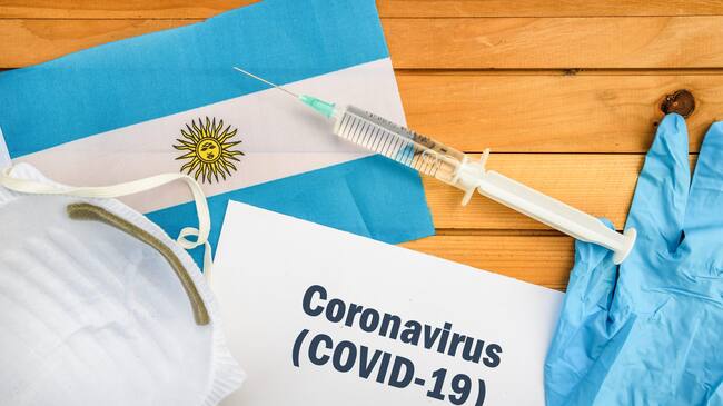 Flag of Argentina , vaccine, face mask for virus, glove and paper sheet with words Coronavirus COVID-19