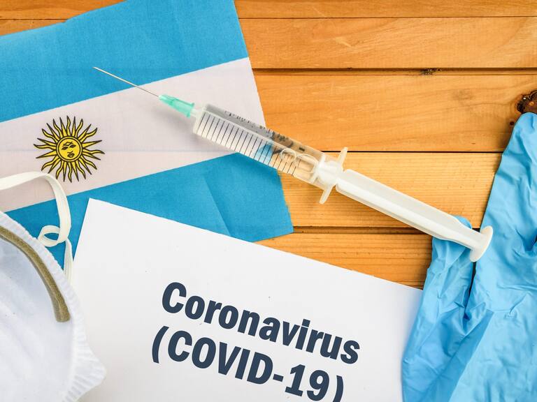 Flag of Argentina , vaccine, face mask for virus, glove and paper sheet with words Coronavirus COVID-19