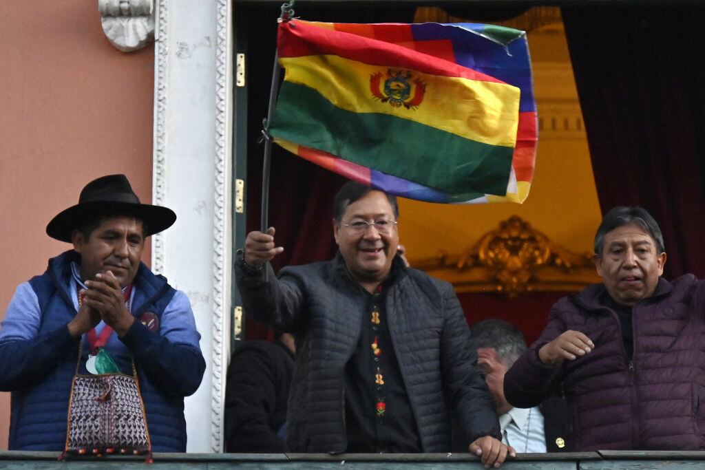 El presidente de Bolivia, Luis Arce, levanta la bandera del país sudamericano en la ciudad de La Paz tres el intento militar golpista.