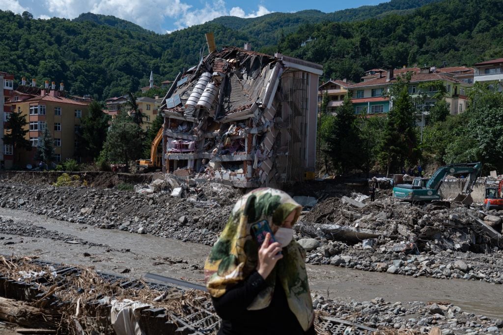 Una mujer pasa ante uno de los edificios colapsado por inundaciones en Turquía