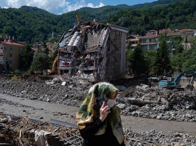 Una mujer pasa ante uno de los edificios colapsado por inundaciones en Turquía