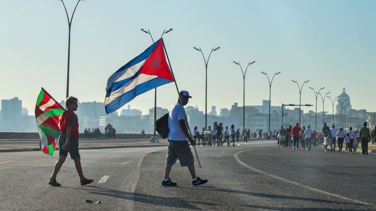 Personas caminan con la bandera de Cuba y del País Vasco tras participar de una manifestación en la ciudad de La Habana