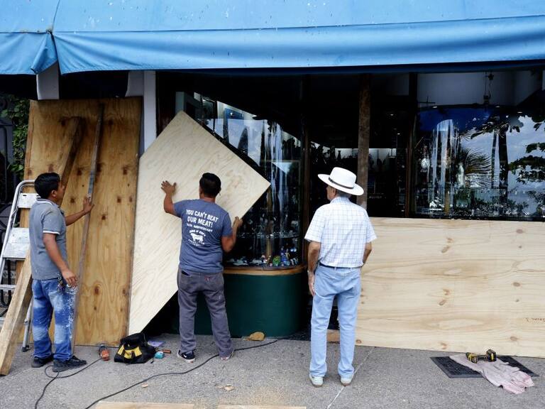 Locatarios protegen las ventanas ante la llegada de Lidia a México