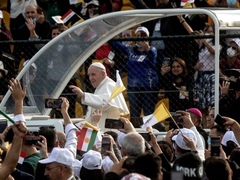 ERBIL, IRAQ - MARCH 07: (EDITORS NOTE: Transmitted with alternate crop) Pope Francis waves to the crowd as he arrives to conduct mass at the  Franso Hariri Stadium on March 07, 2021 in Erbil, Iraq. Pope Francis arrived in Erbil, the final stop of his historic four-day visit, the first-ever papal visit to Iraq. In his first foreign trip since the start of the pandemic, Pope Francis visited Baghdad, Najaf, Erbil, and the cities of Qaraqosh and Mosul, which were heavily destroyed by ISIS. Although the trip is seen as an act of solidarity, the Vatican has been forced to defend the decision to go ahead with the papal visit amid the ongoing coronavirus pandemic, as Iraq is currently seeing a spike in infection rates as it faces a deadly second wave of the virus. (Photo by Chris McGrath/Getty Images)