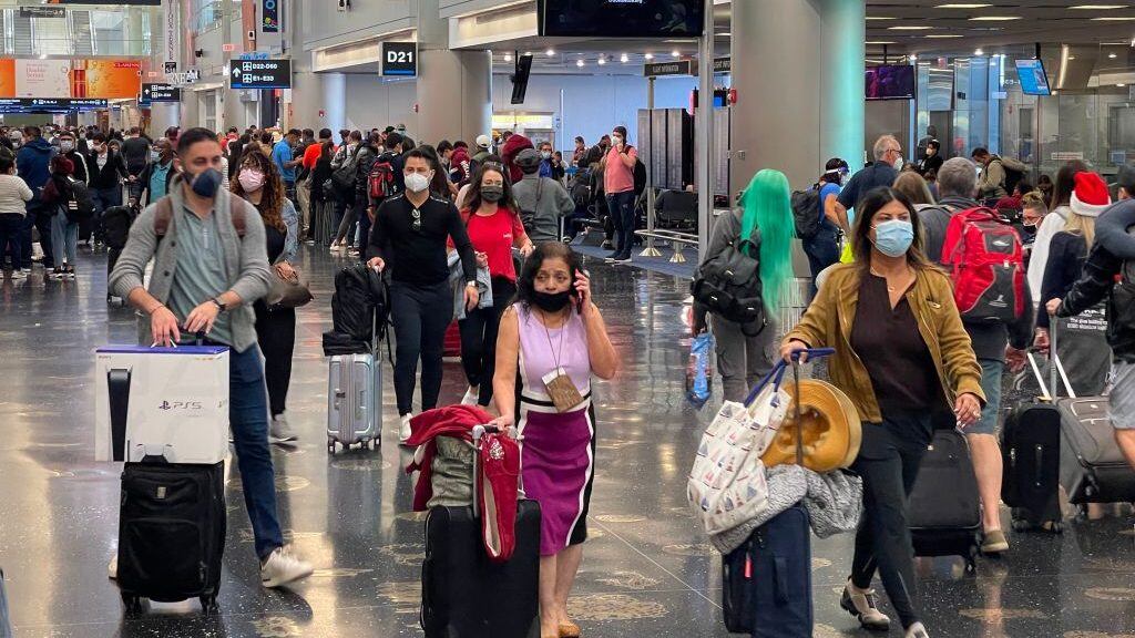Travellers wear facemasks at Miami International Airport on December 24, 2020, amid the coronavirus pandemic. (Photo by Daniel SLIM / AFP) (Photo by DANIEL SLIM/AFP via Getty Images)