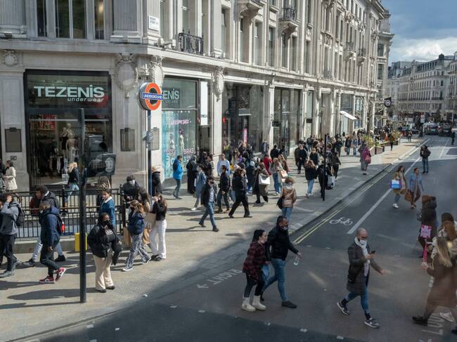 On the day that the UK government eased Covid restrictions to allow non-essential businesses such as shops, pubs, bars, gyms and hairdressers to re-open, crowds of shoppers walk across Oxford Circus, on 12th April 2021, in London, England. (Photo by Richard Baker / In Pictures via Getty Images)