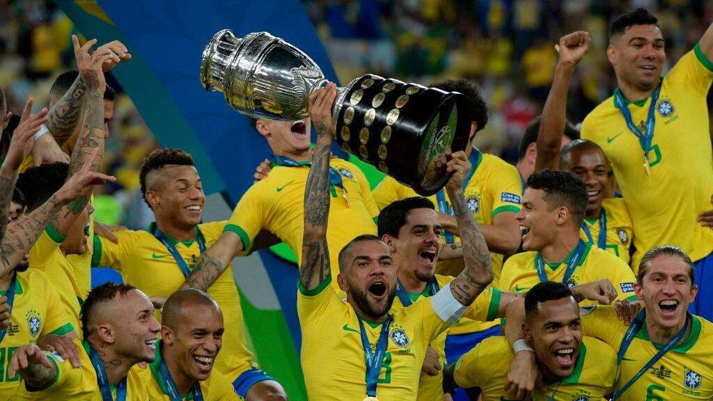 TOPSHOT - Brazil's Dani Alves (C) and teammates celebrates with the trophy after winning the Copa America after defeating Peru in the final match of the football tournament at Maracana Stadium in Rio de Janeiro, Brazil, on July 7, 2019. (Photo by Juan MABROMATA / AFP) (Photo credit should read JUAN MABROMATA/AFP via Getty Images)
