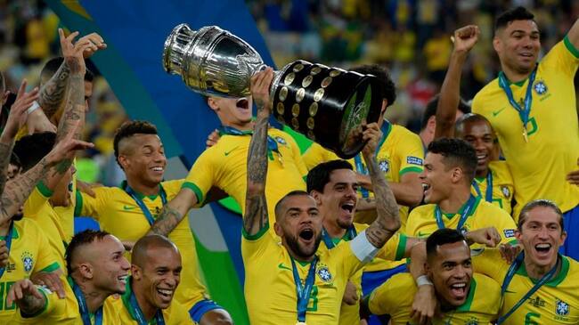 TOPSHOT - Brazil's Dani Alves (C) and teammates celebrates with the trophy after winning the Copa America after defeating Peru in the final match of the football tournament at Maracana Stadium in Rio de Janeiro, Brazil, on July 7, 2019. (Photo by Juan MABROMATA / AFP) (Photo credit should read JUAN MABROMATA/AFP via Getty Images)