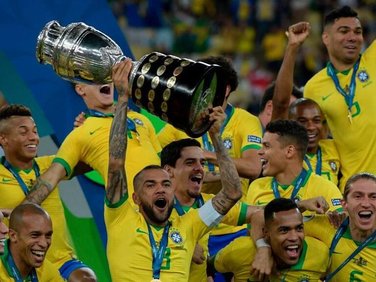 TOPSHOT - Brazil's Dani Alves (C) and teammates celebrates with the trophy after winning the Copa America after defeating Peru in the final match of the football tournament at Maracana Stadium in Rio de Janeiro, Brazil, on July 7, 2019. (Photo by Juan MABROMATA / AFP) (Photo credit should read JUAN MABROMATA/AFP via Getty Images)