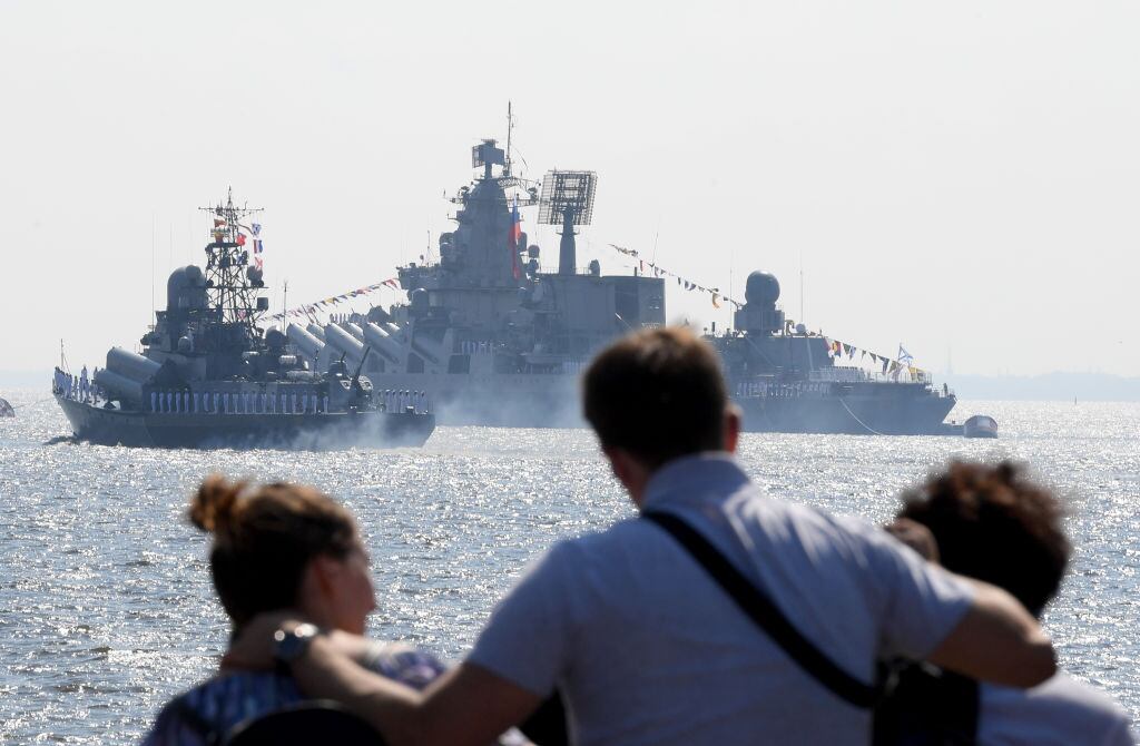 Personas observan el paso de un barco de guerra de la armada de Rusia