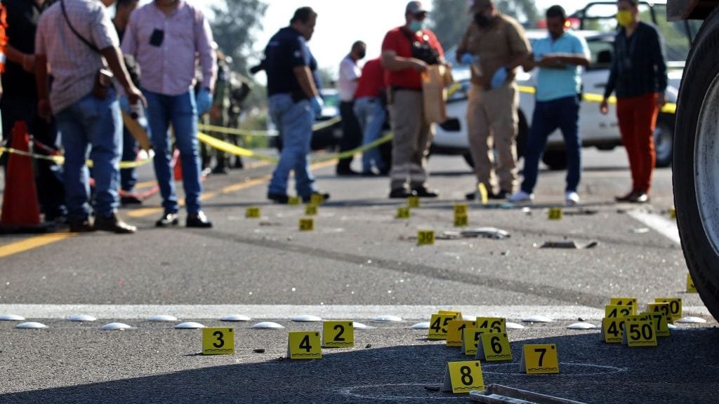 People surround the site where a security transport truck was ambushed by an armed group who killed four private guards in an assault on the Guadalajara-El Arenal highway, Jalisco state, Mexico, on June 19, 2020. (Photo by ULISES RUIZ / AFP) (Photo by ULISES RUIZ/AFP via Getty Images)