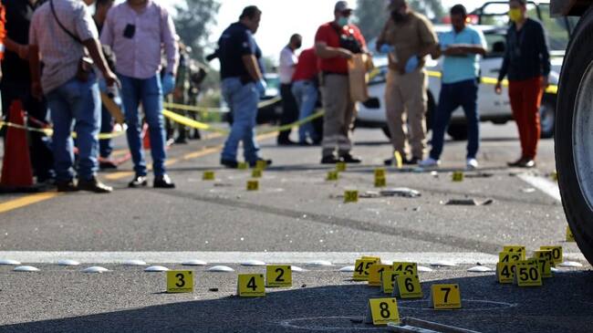 People surround the site where a security transport truck was ambushed by an armed group who killed four private guards in an assault on the Guadalajara-El Arenal highway, Jalisco state, Mexico, on June 19, 2020. (Photo by ULISES RUIZ / AFP) (Photo by ULISES RUIZ/AFP via Getty Images)
