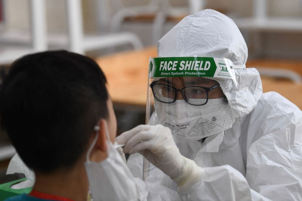 Trabajador de la salud realiza un test de PCR en Hanói