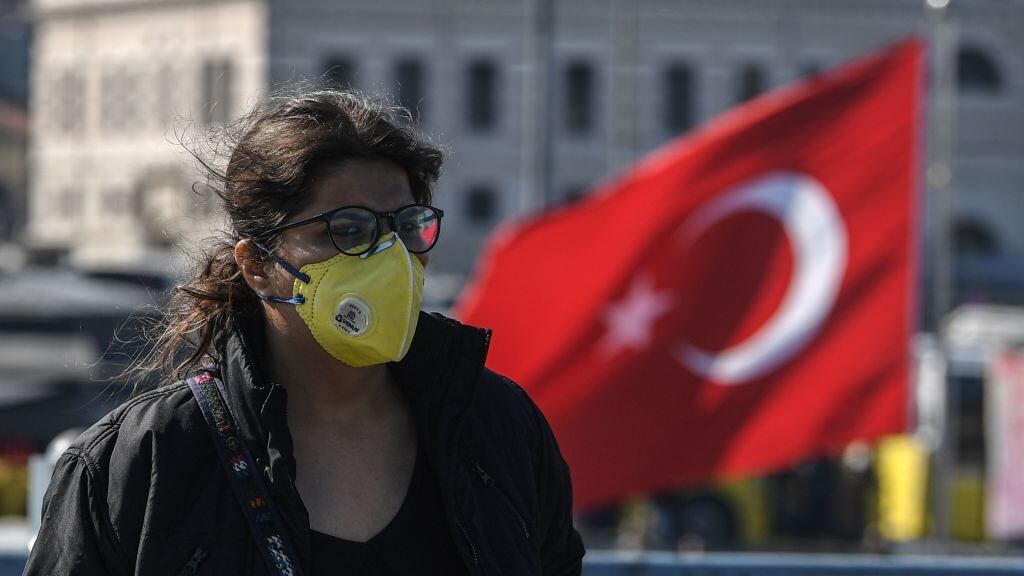 A woman wears a protective face mask as she walks on Galata bridge in Istanbul, on March 13, 2020, amid the outbreak of COVID-19, the new coronavirus. - Turkey said on March 12 it would shut all schools for two weeks and bar spectators from football matches through April after recording its first case of the new coronavirus. The death toll from the coronavirus pandemic has risen to 5,043, according to an AFP tally based on official sources at 1100 GMT on March 13. Since COVID-19 was first detected in December 2019, more than 134,300 people have been infected in 121 countries and territories. (Photo by Ozan KOSE / AFP) (Photo by OZAN KOSE/AFP via Getty Images)