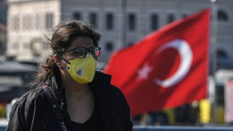 A woman wears a protective face mask as she walks on Galata bridge in Istanbul, on March 13, 2020, amid the outbreak of COVID-19, the new coronavirus. - Turkey said on March 12 it would shut all schools for two weeks and bar spectators from football matches through April after recording its first case of the new coronavirus. The death toll from the coronavirus pandemic has risen to 5,043, according to an AFP tally based on official sources at 1100 GMT on March 13. Since COVID-19 was first detected in December 2019, more than 134,300 people have been infected in 121 countries and territories. (Photo by Ozan KOSE / AFP) (Photo by OZAN KOSE/AFP via Getty Images)