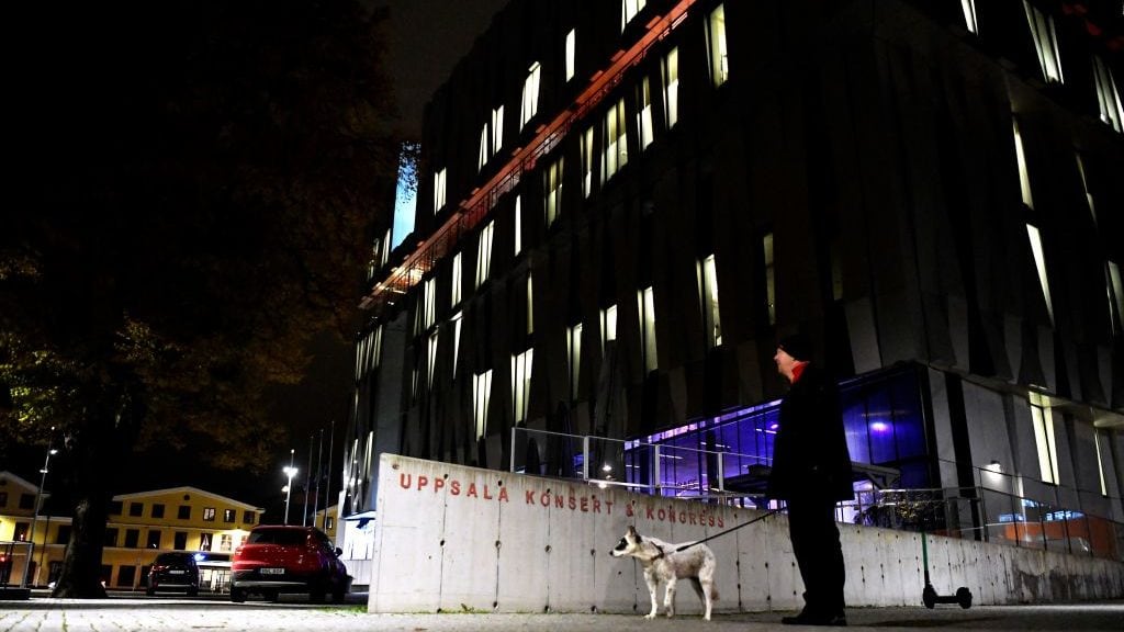 A man holds a dog on the leash at night as he stands in front of the concert hall "Uppsala Konsert &amp; Kongress" in Uppsala, Sweden, on November 2, 2021. - Two people died and one was injured on November 2, 2021 in Sweden's Uppsala after an elderly man fell seven floors, hitting two people, at a concert hall, police said, that was hosting a tribute concert to ABBA legends Bjorn Ulvaeus and Benny Andersson. - Sweden OUT (Photo by Anders WIKLUND / TT News Agency / AFP) / Sweden OUT (Photo by ANDERS WIKLUND/TT News Agency/AFP via Getty Images)