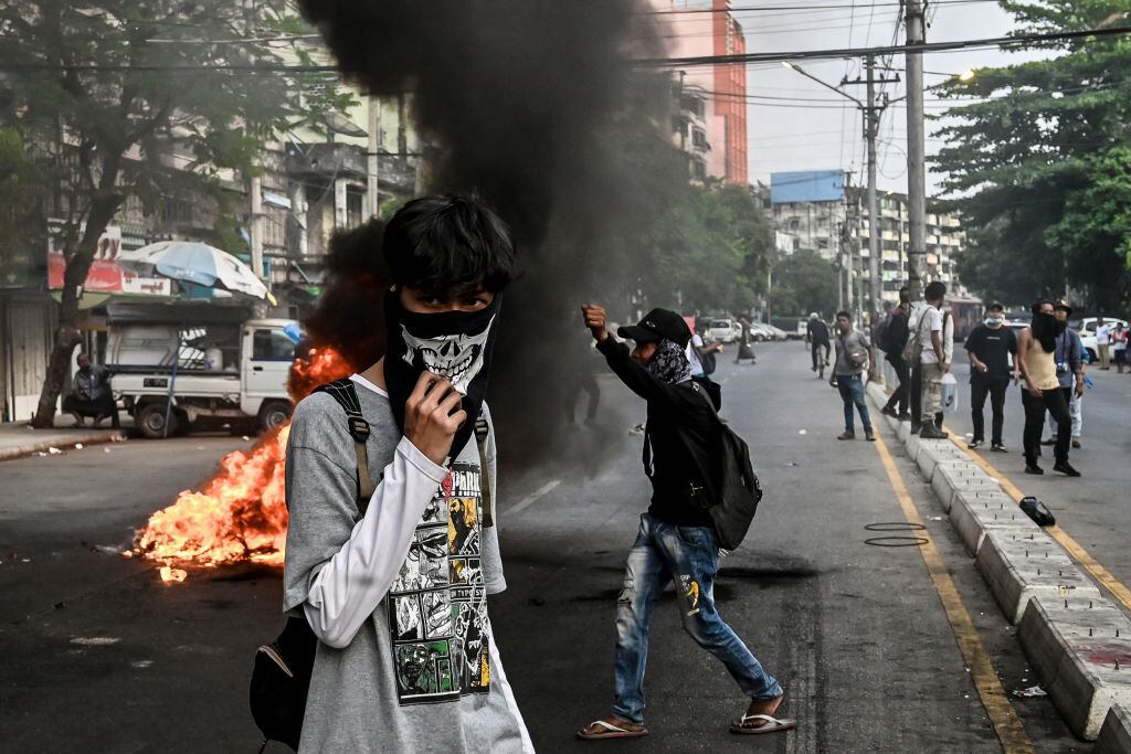 Manifestantes incendian una barricada para impedir el paso de agentes de la dictadura en Rangún