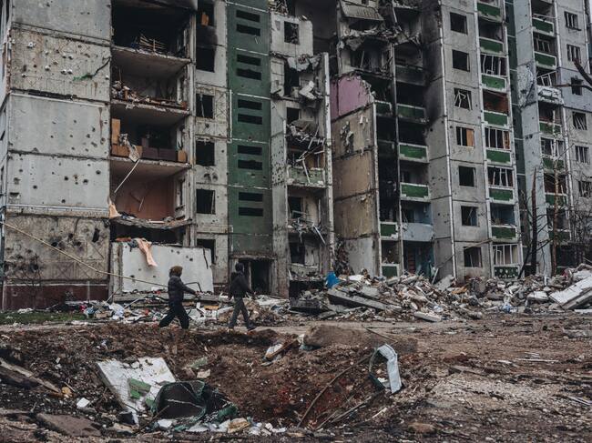Una pareja pasa ante un edificio destruido en la ciudad de Chernihiv