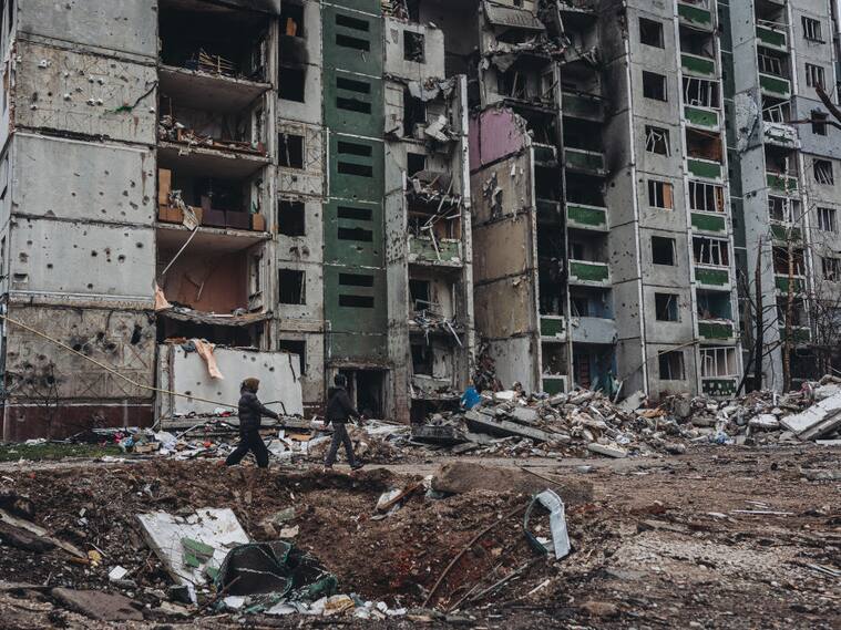 Una pareja pasa ante un edificio destruido en la ciudad de Chernihiv
