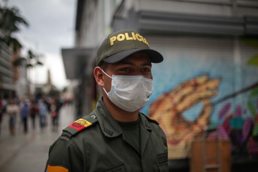 Un funcionario policial colombiano utiliza mascarilla mientras cumple sus labores